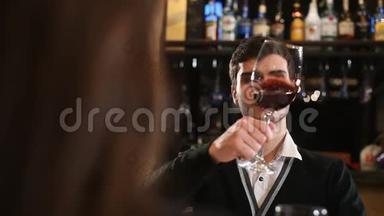 一个人拿着红酒在杯子里摇晃着品尝。 检查红酒的品质